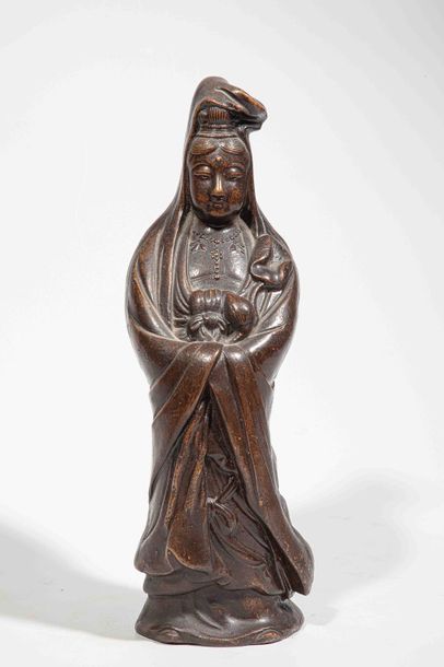 null Le Boddhisattva Kwan Yin figuré debout vêtu d'une robe monastique lui couvrant...