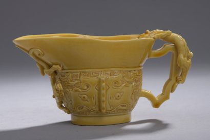 null Jolie petite coupe libatoire en porcelaine émaillée jaune. Des masques de taotie...