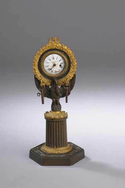 null Porte-montre formant pendulette en bronze patiné et bronze doré. Le cadran,...