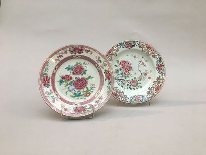null Deux assiettes en porcelaine de la famille rose à décor de fleurs, l'aile richement...