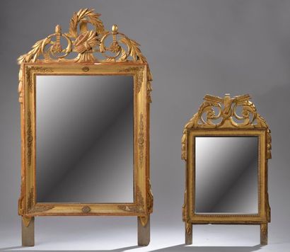null Miroir en bois sculpté et doré à course de perles, le fronton à décor d'un luth...