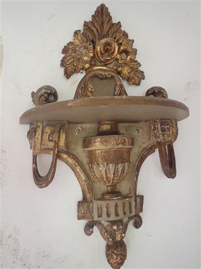 Une paire de consoles d'appliques en bois sculpté et doré à motif central d'un vase,...