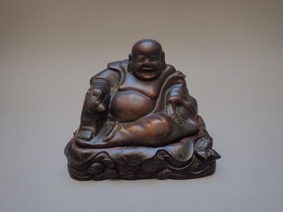 null Bouddha en bronze à patine brune sur son socle en bois sculpté de motifs feuillagés....