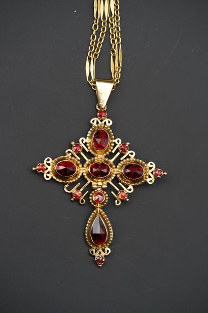 null A bâdine cross in 18K yellow gold, set with faceted oval and pear-shaped almandine...