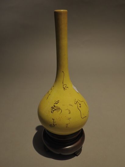 null Vase de forme bouteille soclé, à glaçure jaune et décor brun. Marque sous la...