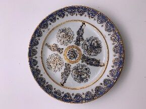 null Assiette en porcelaine émaillée blanc bleu et rehaut or, à décor central d'un...