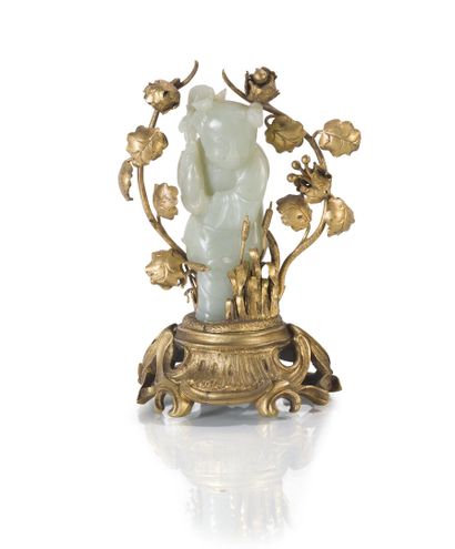 null Sujet en jade celadon monté sur une base en bronze rehaussée de vignes et roseaux....