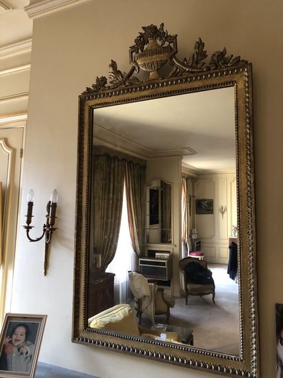 null Miroir de style Louis XVI en bois doré à frontons orné d'un vase couvert. 

Hauteur...