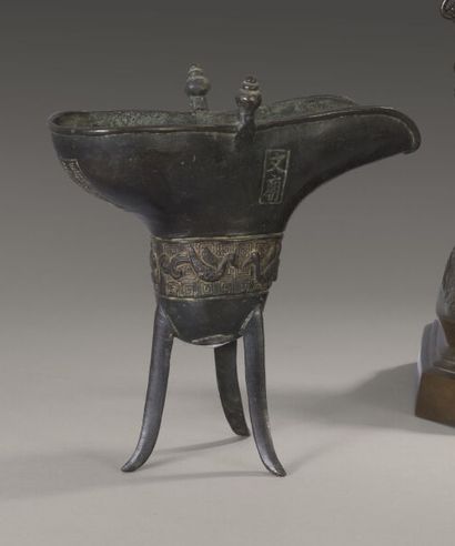 null Vase Jue de forme archaïque tripode en bronze . La panse à décor de quatre oiseaux....