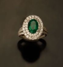 null Daisy ring in 18K (750 °/°°) white gold set with an oval emerald in a double...