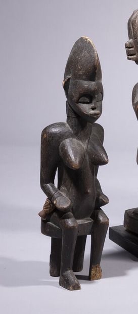 null Seated female statue with dark patina, left feet missing. 

Senoufo, Ivory Coast

Height...