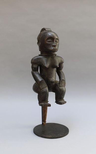 null Seated statue of a reliquary box keeper in wood with black patina. Iron bracelets...