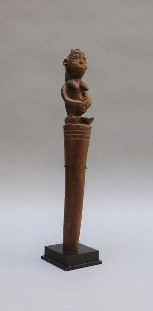 null Wooden stake with light brown patina. Seated female figure holding a cup. 

Tabwa,...