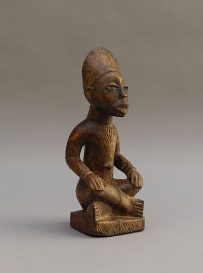 null Seated male statuette in a cross-legged position in wood with a light patina....