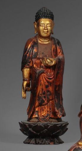 null Small Buddha in red and gold lacquered wood. Standing with hands in mudra holding...