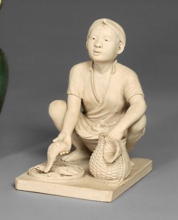 null Porcelain stoneware subject representing a seated fish merchant. Marked "H.U.T."...