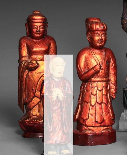 null Two carved and lacquered wooden figures, one depicted as an offering, the left...