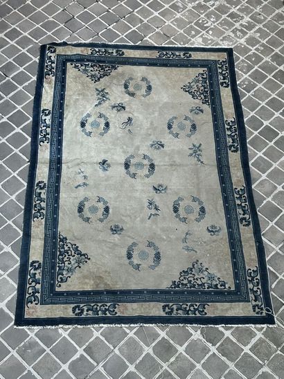 null 
Large carpet with cream background decorated with blue motifs, blue border...