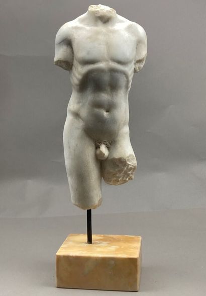 null Torso of an acephalous man in sculpted white marble. Resting on a yellow marble...