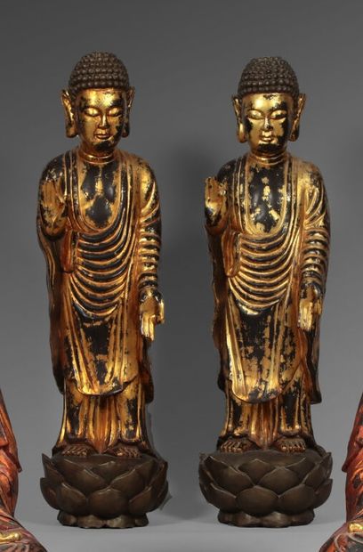Deux bouddhas en bois laqué rouge et or représentés...