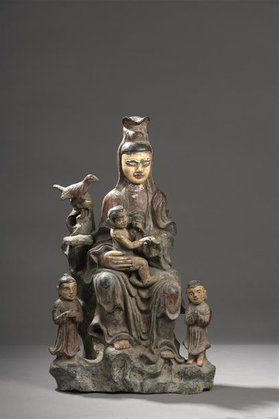 null Quan Âm (Guanyin), la déesse de la Compassion, 

assise sur un rocher avec trois...