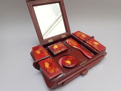 null Coffret de toilette en bois laqué rouge à décor de poissons. Il ouvre à un abattant...