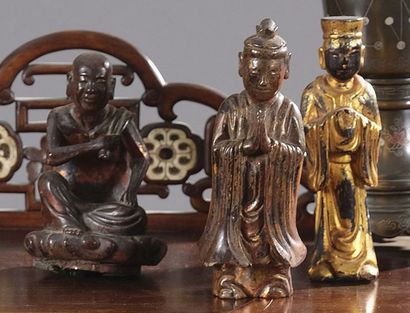 null Trois statuettes en bois laqué or représentant des personnages priant. Indochine,...
