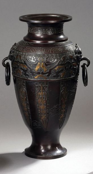 null Vase balustre en bronze à deux anses, la col ciselé de têtes de gloutons et...