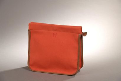 null Hermès. Pochette en toile rouge orangé à fermeture zippée. 
État neuf. Avec...