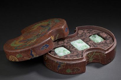  Trois pendentifs en jadéite et leur boîte en bois laqué Chine Les pendentifs à décor...