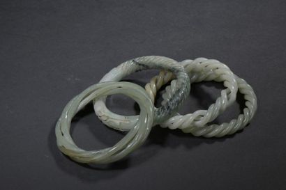 Quatre bracelets en jade céladon Chine Torsadés,...