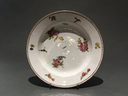 null Paris XVIIIe siècle 
Assiette en porcelaine à décor floral, filet bleu et dent...