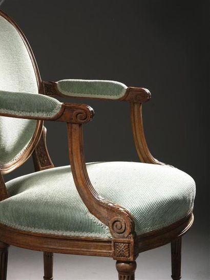 null Suite de quatre larges fauteuils en bois naturel mouluré et sculpté estampillés...