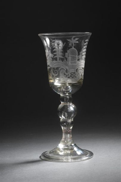 null Holland, 18th century Tulip-shaped stemmed
glass, it rests on a baluster. Engraved...