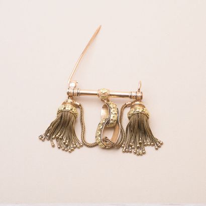 null Gold barrette brooch holding two tassels and a pattern of interlaced circles.

About...