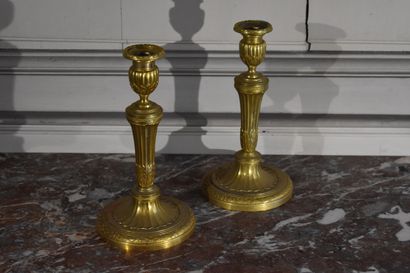  Paire de bougeoirs en bronze ciselé et doré de style Louis XVI 
A décor de godrons,...