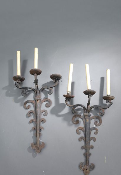A pair of wrought iron sconces decorated...