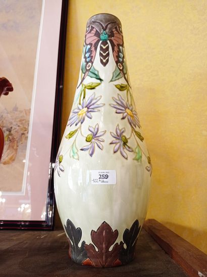  LONGCHAMP, terre de fer Vase en faïence émaillée à décor floral et papillons vers...