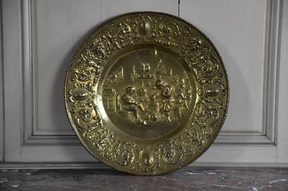 null A large brass offering plate in the 17th century style

Decorated with a tavern...