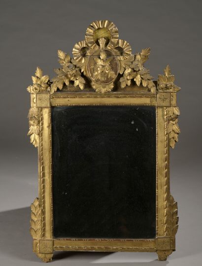 null A Louis XVI period carved and gilded wood bevelled mirror

Decorated with a...