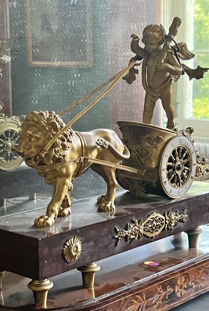 null Pendule en bronze ciselé et doré, époque Empire.

A décor d'un char conduisant...