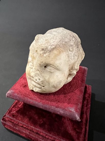 null Fragment de tête d'enfant en marbre sculpté. 
Époque romaine. 
H. 8 cm 