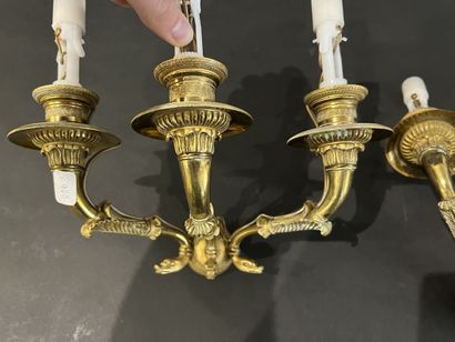 null A pair of Empire style gilt bronze three-light sconces, decorated with dolphins....
