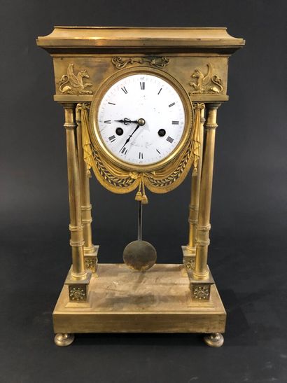 null Empire-period gilt and chased bronze portico clock.
The dial signed Greber in...