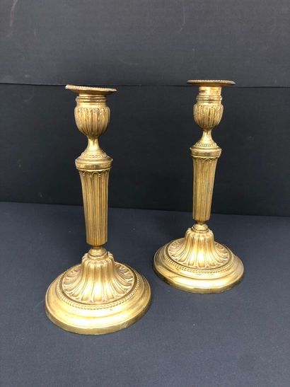null PAIR OF FLAMBEAUX in chased and gilded bronze, with fluted shafts, resting on...