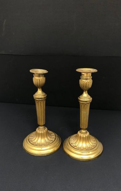 null PAIR OF FLAMBEAUX in chased and gilded bronze, with fluted shafts, resting on...