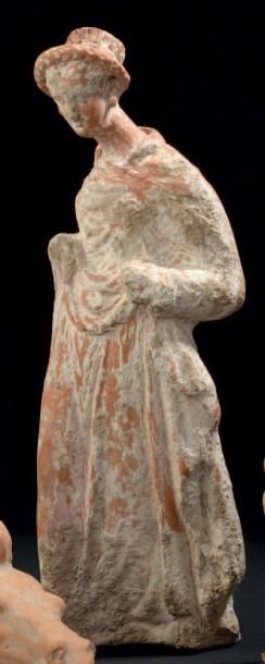 null Statuette représentant une jeune femme vêtue d'un long chiton. Argile beige....