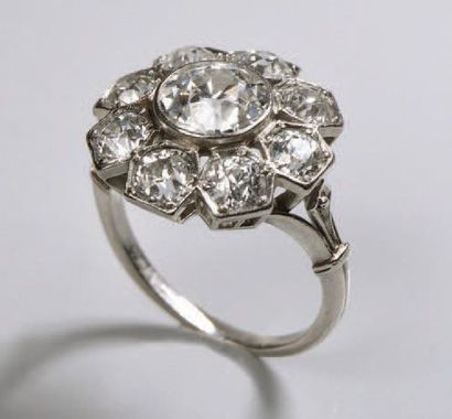 null Bague marguerite en platine (950) ornée d'un diamant demi taille entouré de...