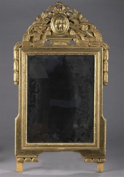 null Glace en bois sculpté et doré d'époque Louis XVI.
Le fronton à décor d'un cartouche...