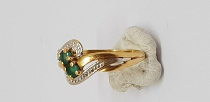 null Lot: Yellow gold ring, 750MM, decorated with two emeralds and a 750MM yellow...